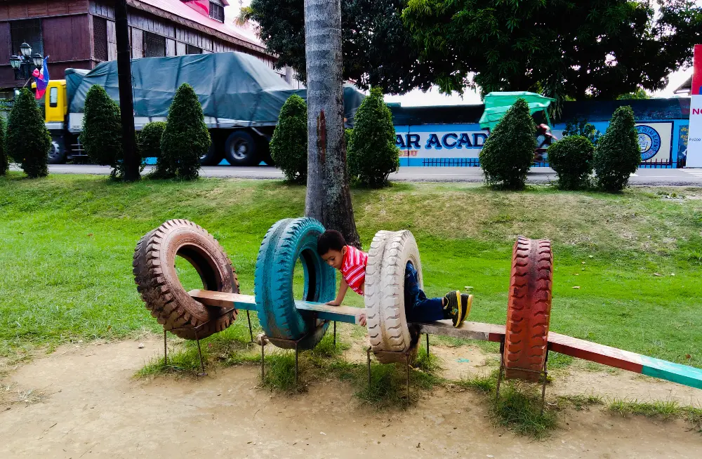 Boy Crawling Through Backyard Tire Tunnel