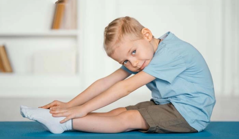 Child Doing a Seated Stretch Indoors