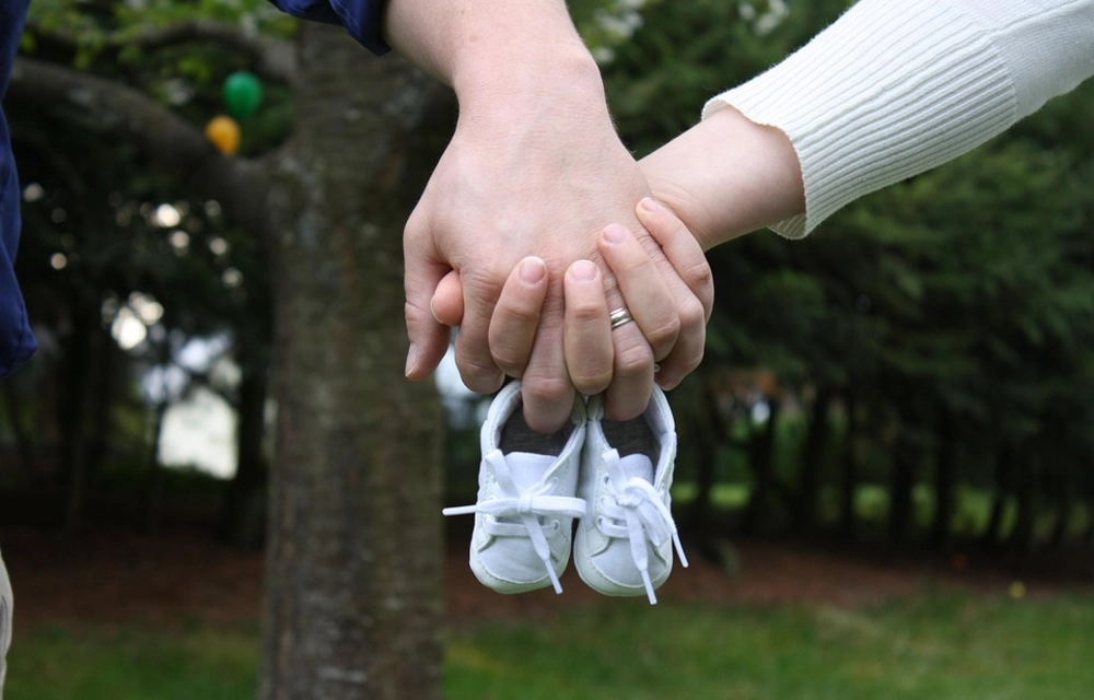 Holding Hands With Baby Shoes