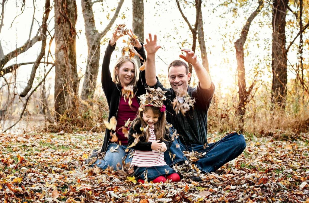 Joyful Leaf Toss Family Portrait in Autumn Woods