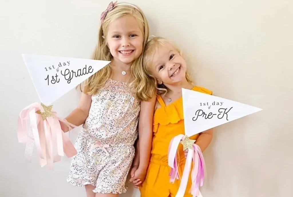 Sisters Holding School Pennant Flags with Star Wands