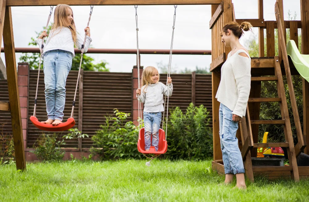 Sisters Swinging Together on Backyard Play Set