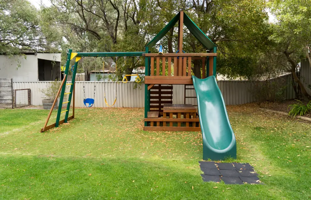 Wooden Backyard Fort with Green Slide and Swings